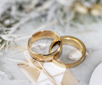 gold wedding band on white textile