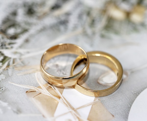 gold wedding band on white textile