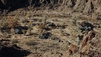 A compact modular factory unit with green roofs, set in a rural Namibian landscape.