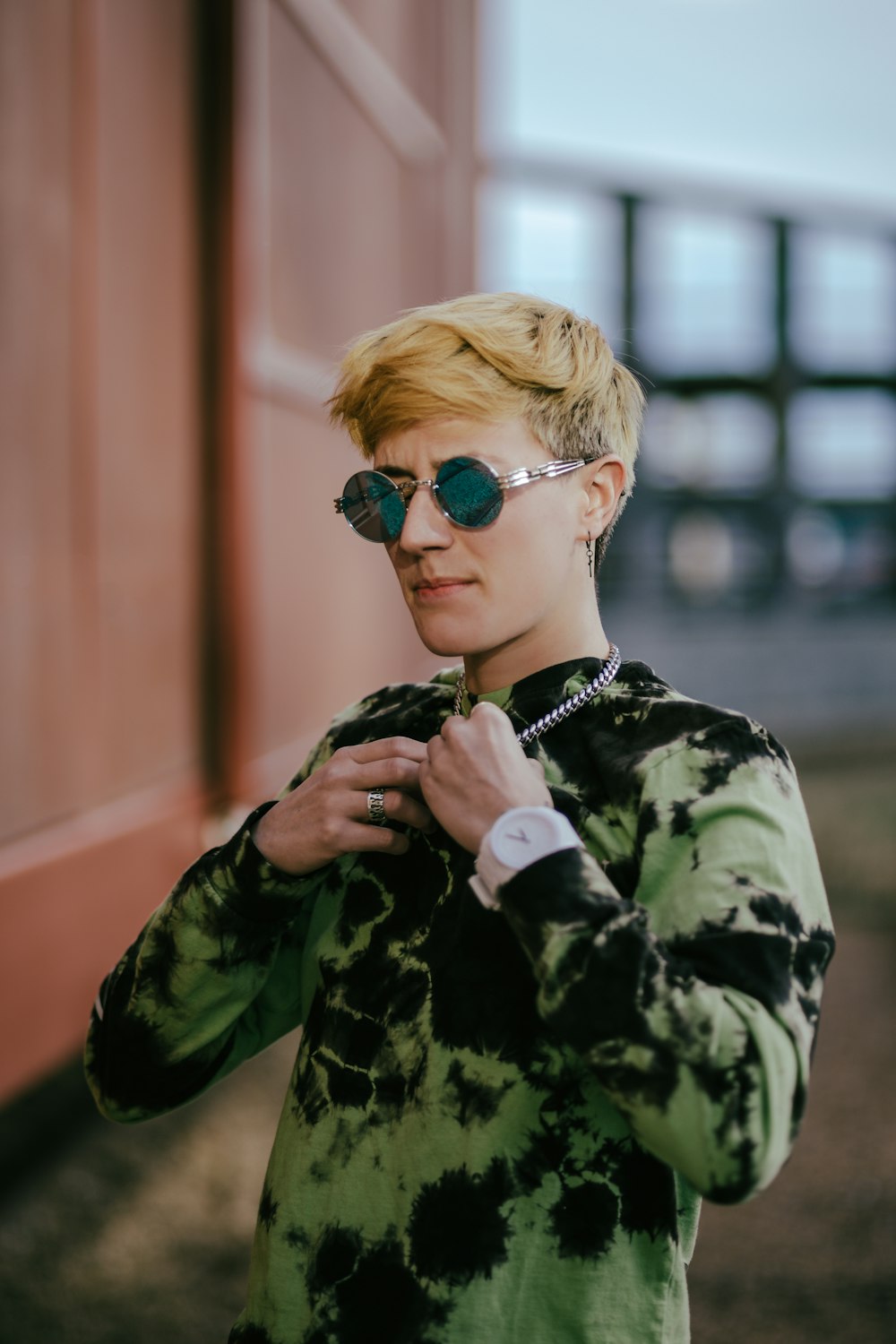 boy in green and black camouflage jacket wearing blue sunglasses