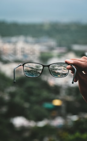 person holding black framed eyeglasses