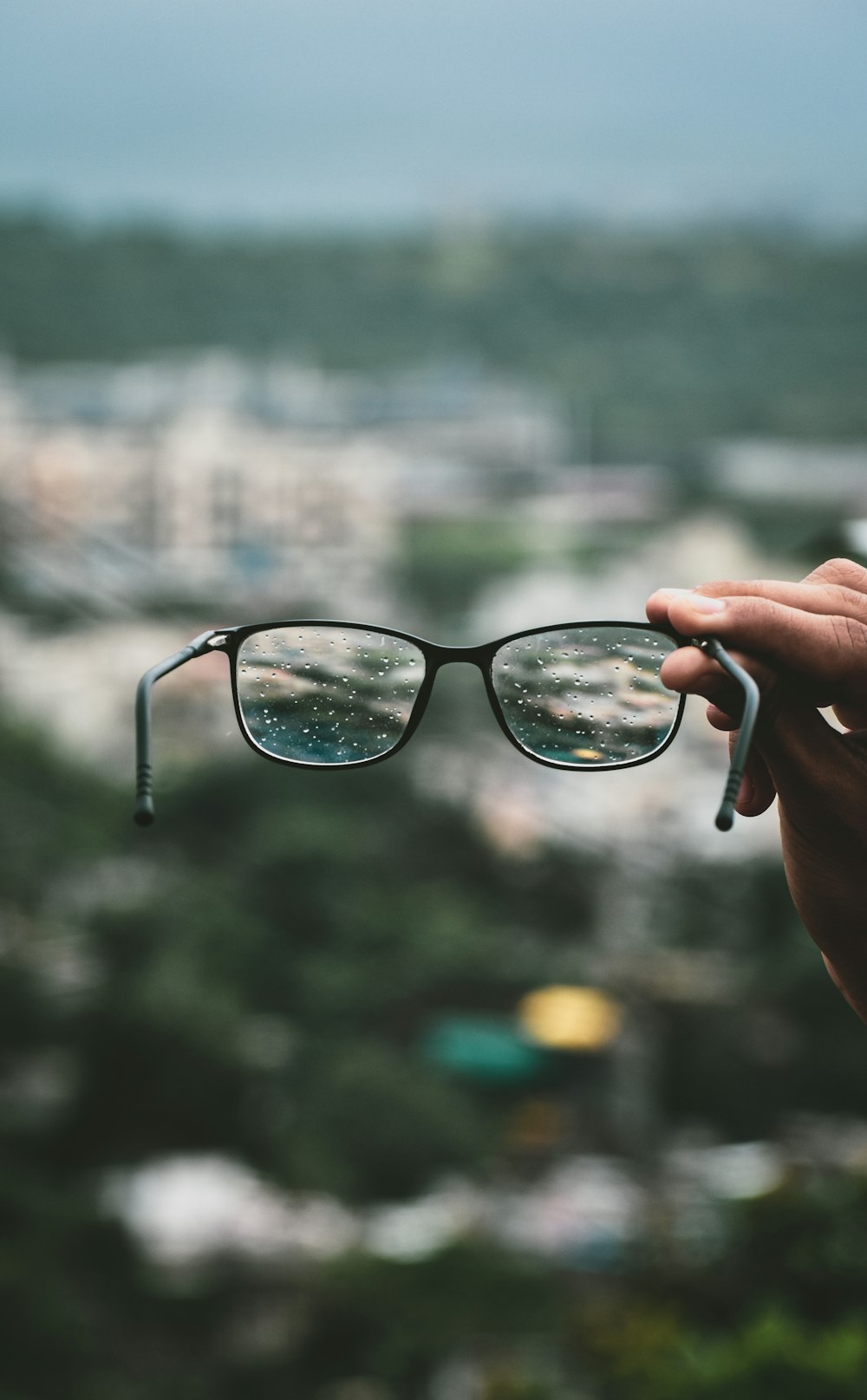 person holding black framed eyeglasses