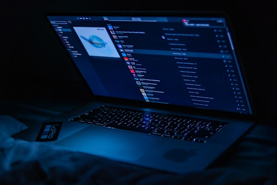 A laptop screen displaying music files being copied from an iPhone to a PC.