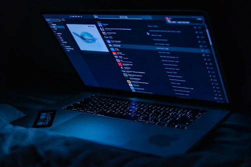 A sleek laptop screen showing a dynamic playlist interface with black and silver theme colors.