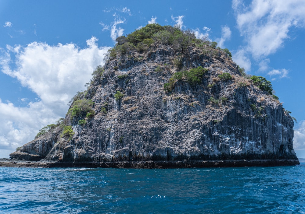 gray and green mountain beside body of water during daytime