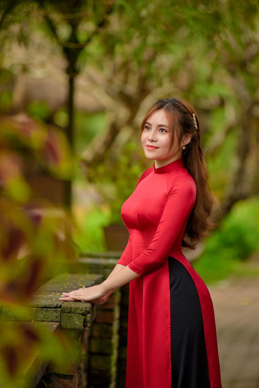 woman in red long sleeve dress standing on gray concrete surface