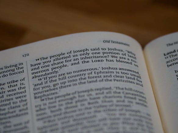 An open book displaying a passage from the Old Testament, specifically the book of Joshua. The text discusses the people of Joseph and their inheritance of land. The page is numbered 172, and the book includes chapter and verse numbers.