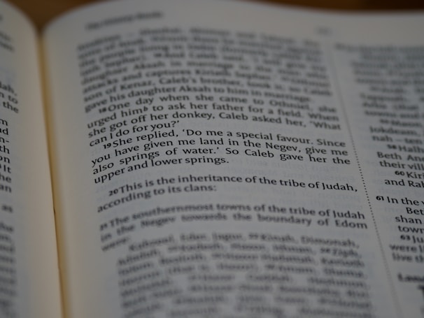 A close-up of a hand turning the pages of a sacred scripture.