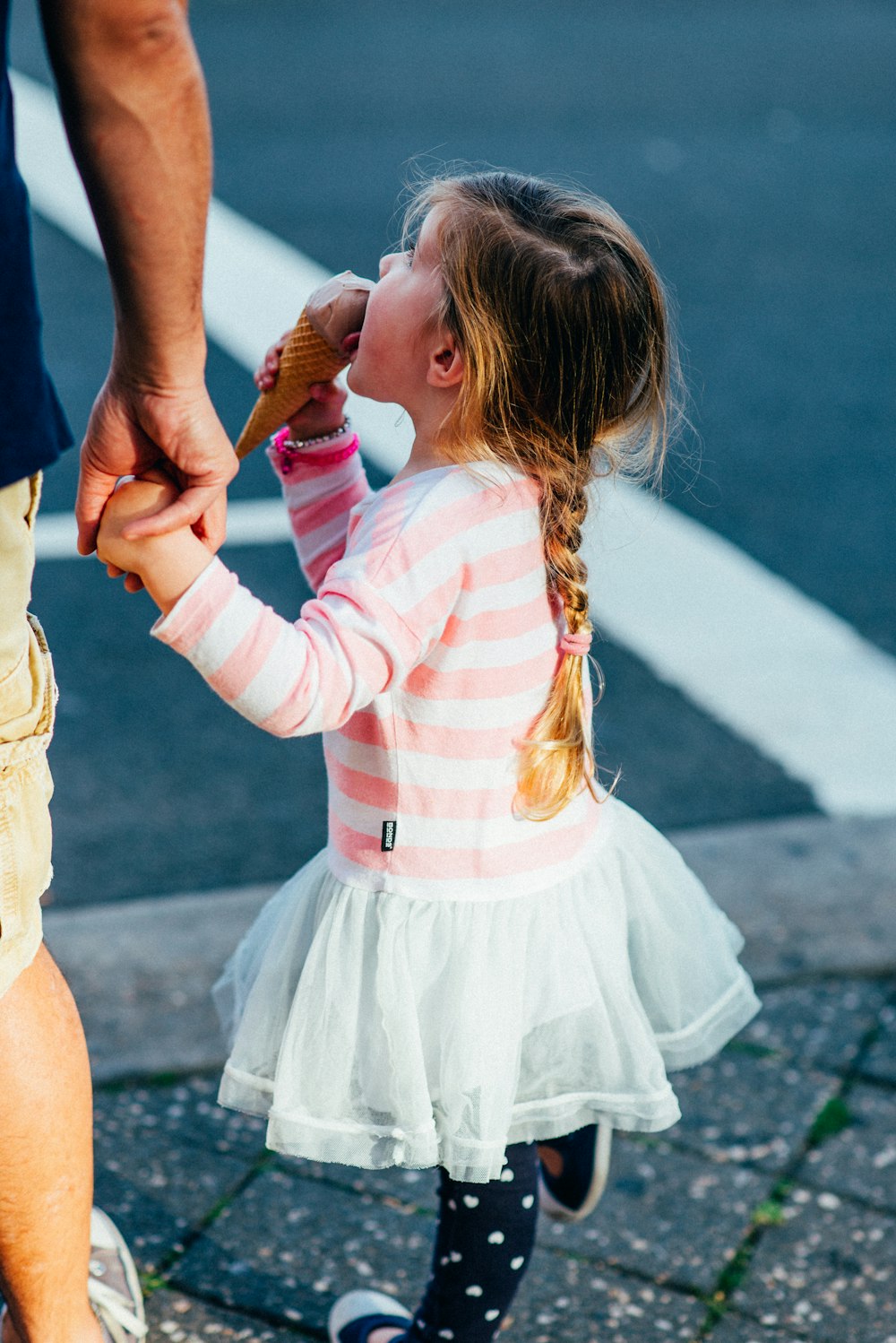 girl in pink and white striped long sleeve shirt and white skirt