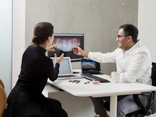 man in white dress shirt sitting beside woman in black long sleeve shirt