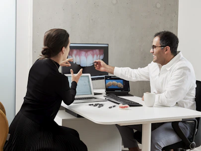 man in white dress shirt sitting beside woman in black long sleeve shirt
