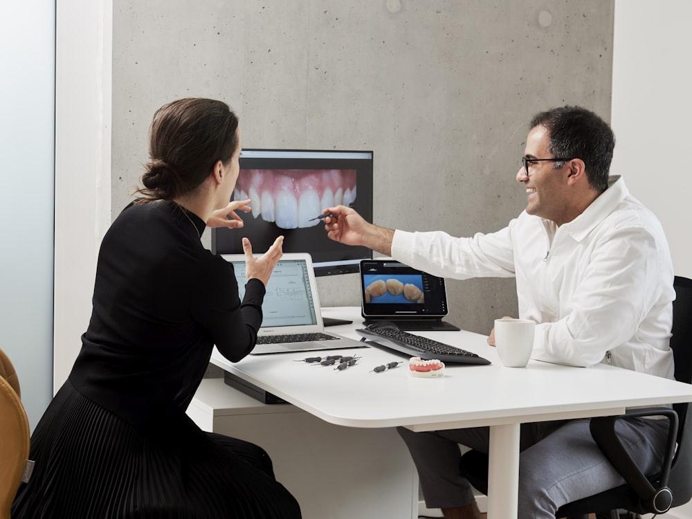 man in white dress shirt sitting beside woman in black long sleeve shirt