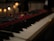 Close-up of a vintage synthesizer and drum kit in a warmly lit studio environment.