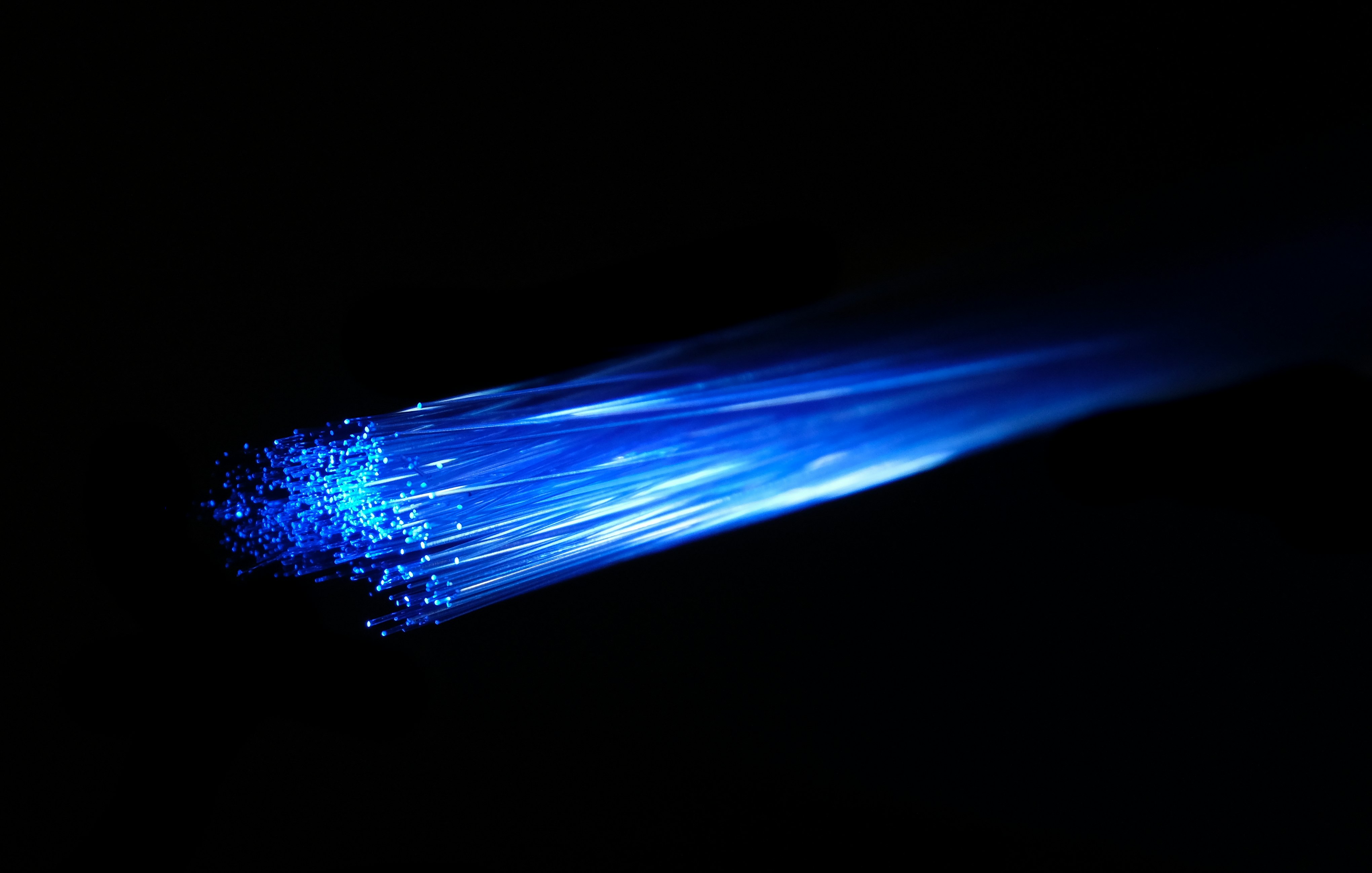 Blue light passing over fibre optic cable. The fiber optic is very vivid and striking. Ideal image for depicting superfast gigabit fibre broadband, networks, networking and other internet technology.