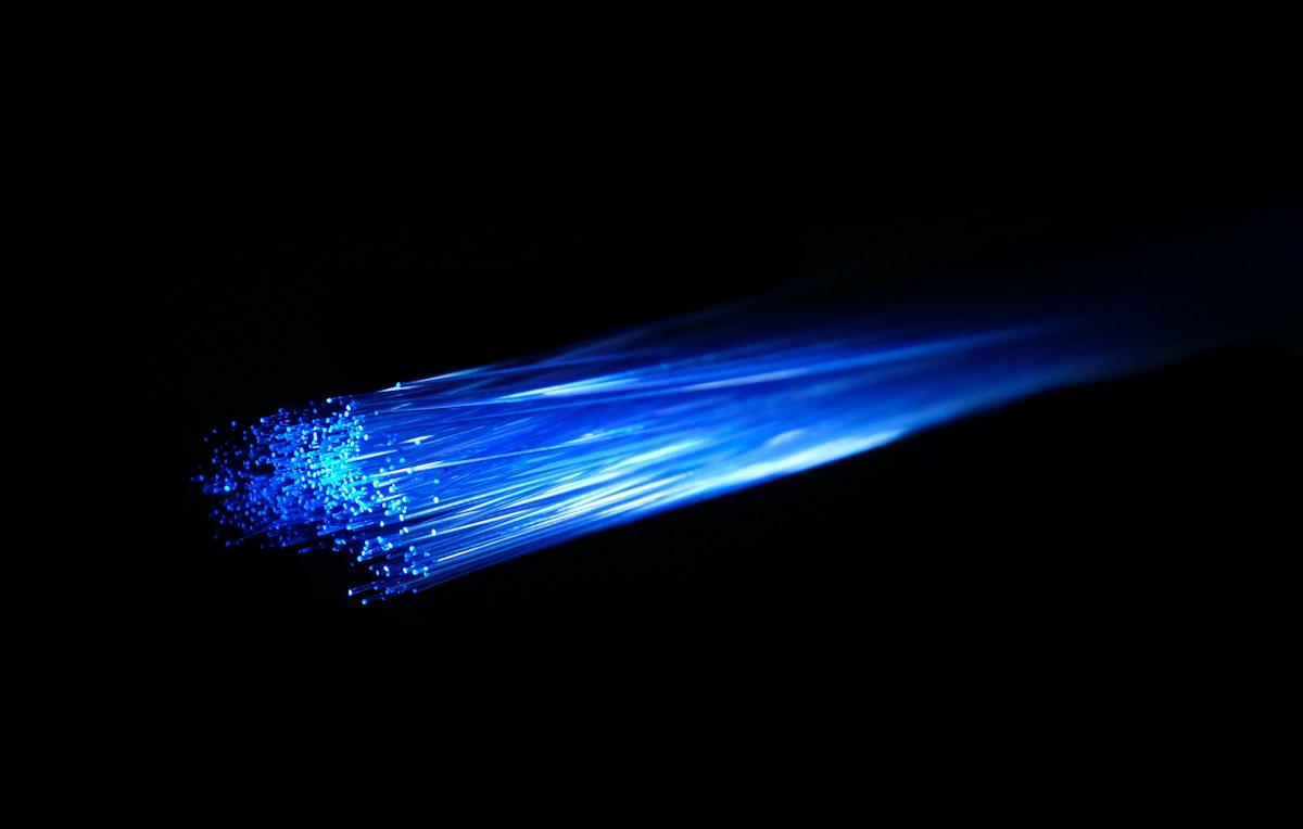 Luz azul passando por cabos de fibra óptica no escuro