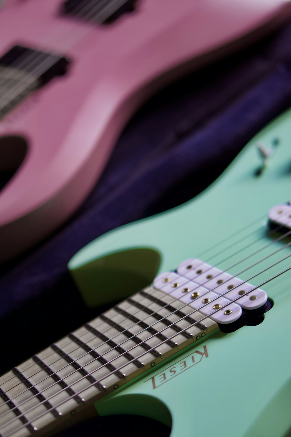 pink electric guitar on black textile