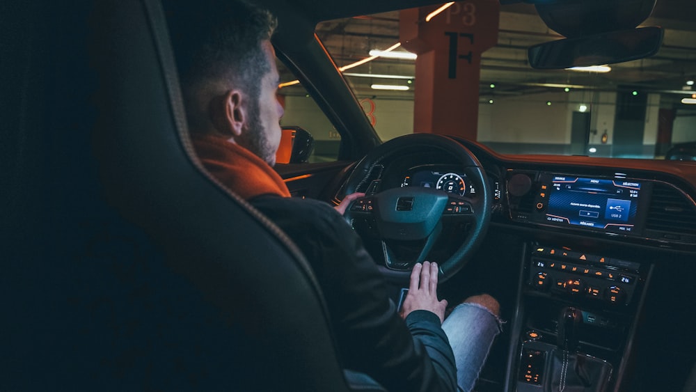 man in black jacket driving car