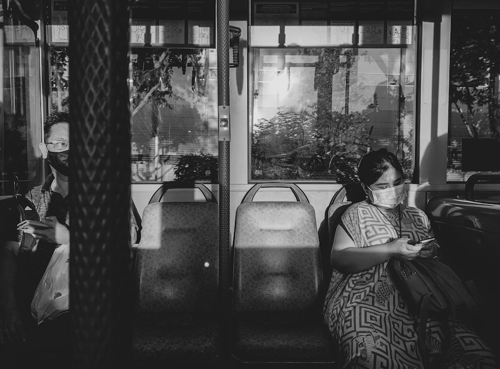 grayscale photo of woman sitting on car seat