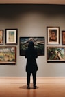 woman in black coat standing in front of paintings