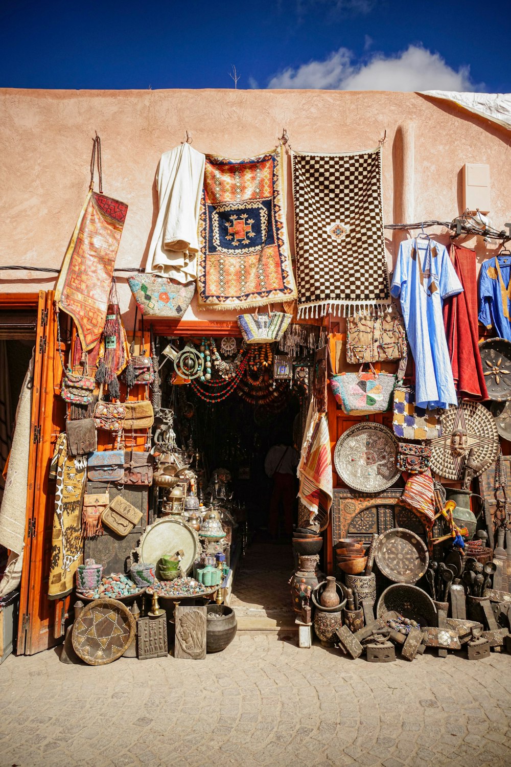 assorted clothes hanged on brown wooden cabinet