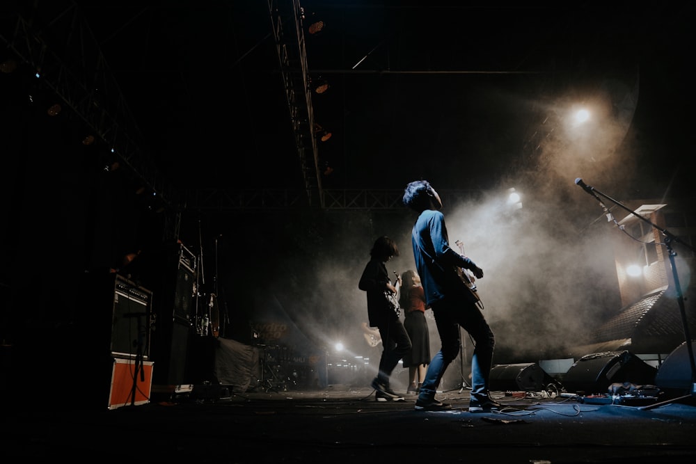 man in blue jacket and black pants playing skateboard on stage