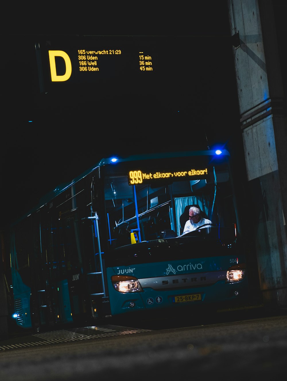 Hombre con camisa blanca viajando en autobús durante la noche