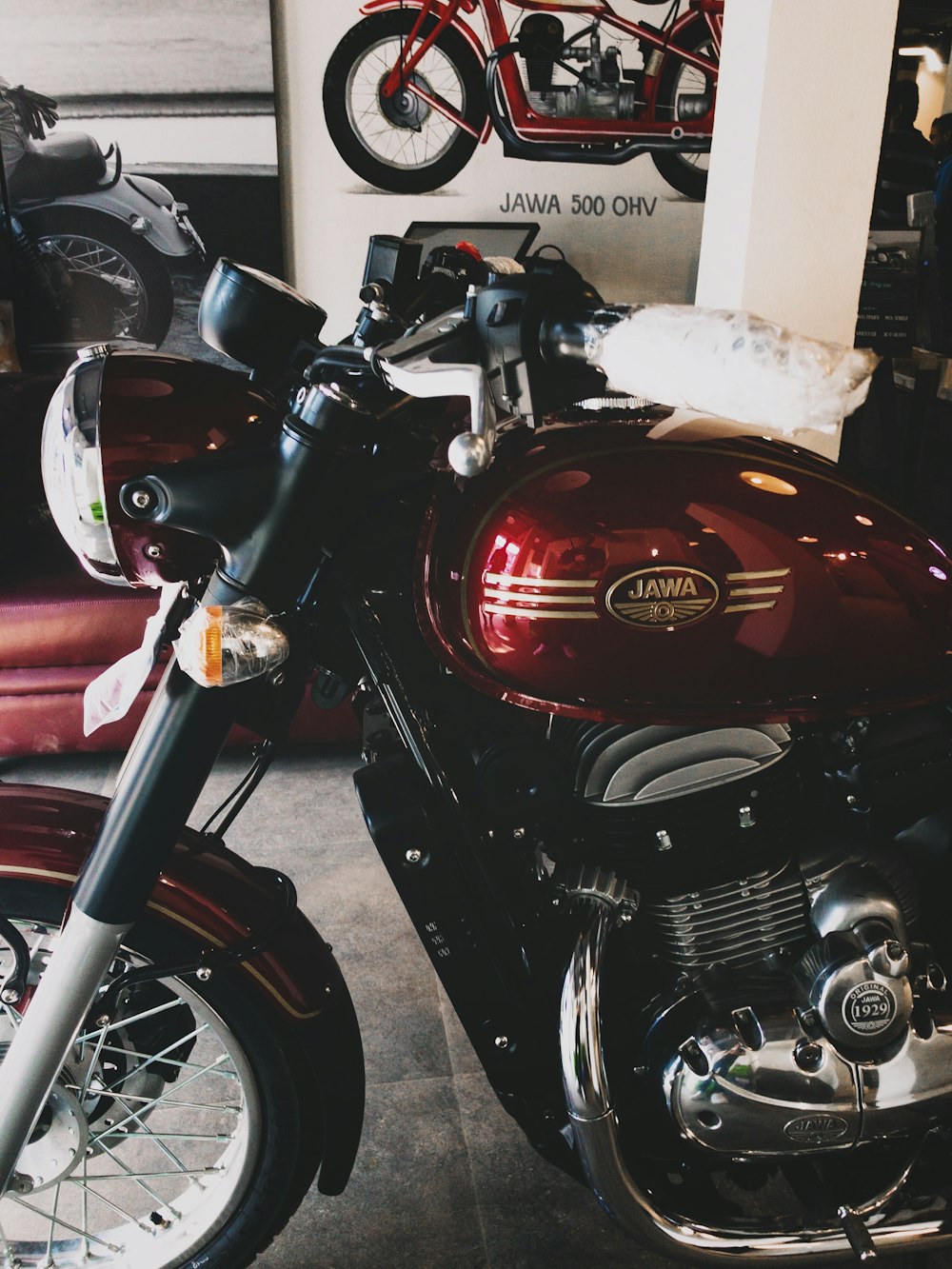 red and black motorcycle parked beside white wall