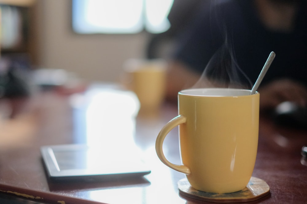 yellow ceramic mug on saucer