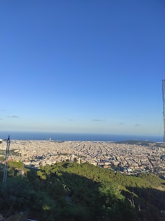 A panoramic view of a city skyline with communication towers.