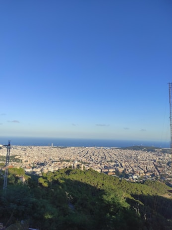 A panoramic view of a city skyline with communication towers.
