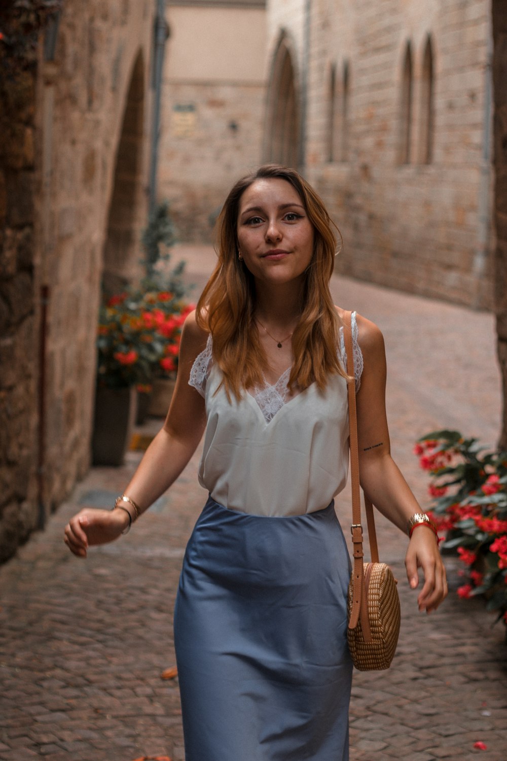 woman in white tank top and blue denim skirt wearing black framed eyeglasses