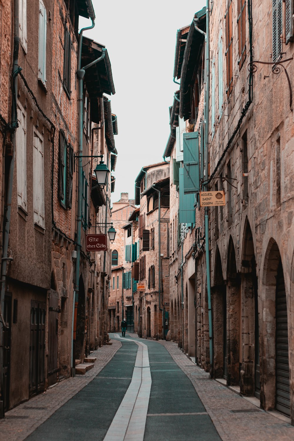 empty street between concrete buildings during daytime