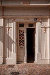 An inviting wooden door with intricate carvings, freshly varnished and shining.