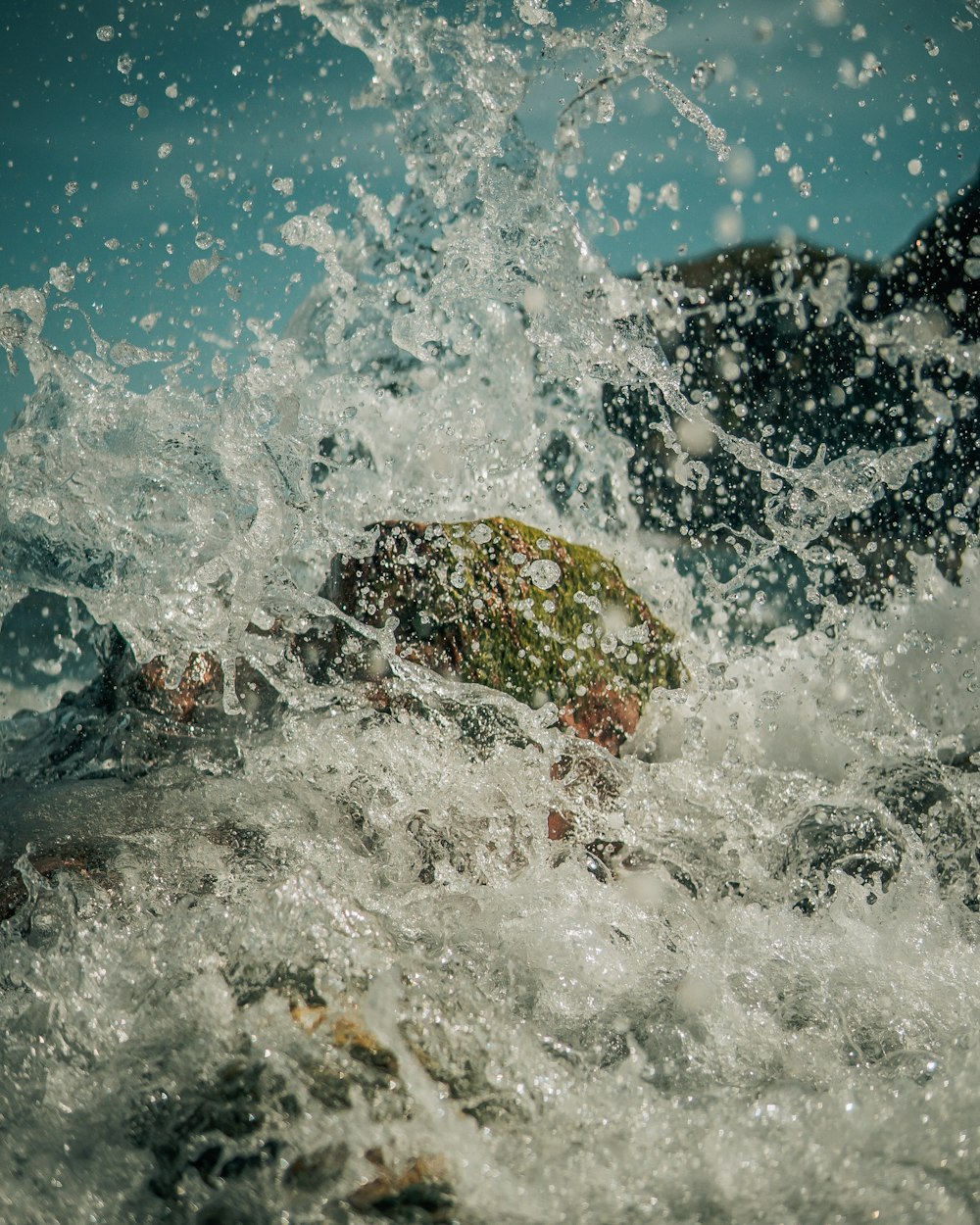 Le onde d'acqua colpiscono le rocce durante il giorno