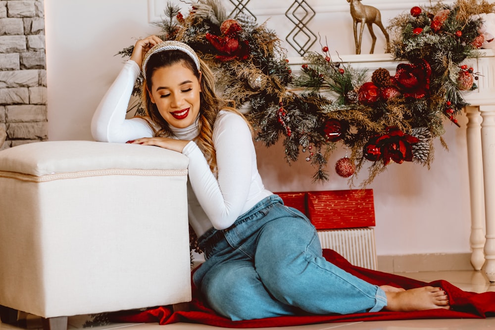 woman in white long sleeve shirt and blue denim jeans sitting on white couch