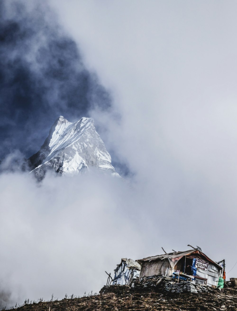 brown house near mountain covered with snow