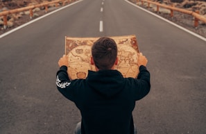 man in black jacket holding brown box