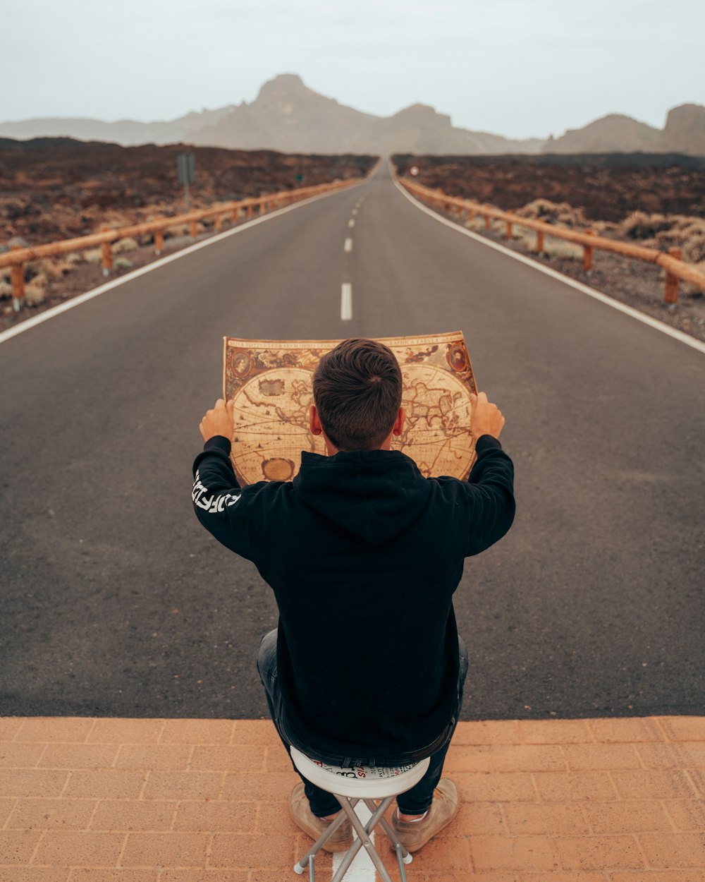 man in black jacket holding brown box