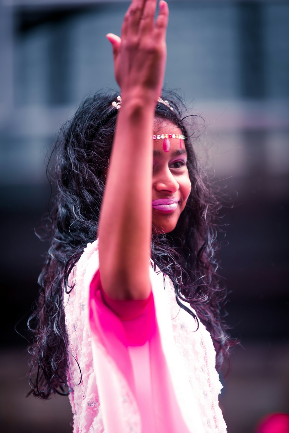 girl in white and pink shirt raising her hands