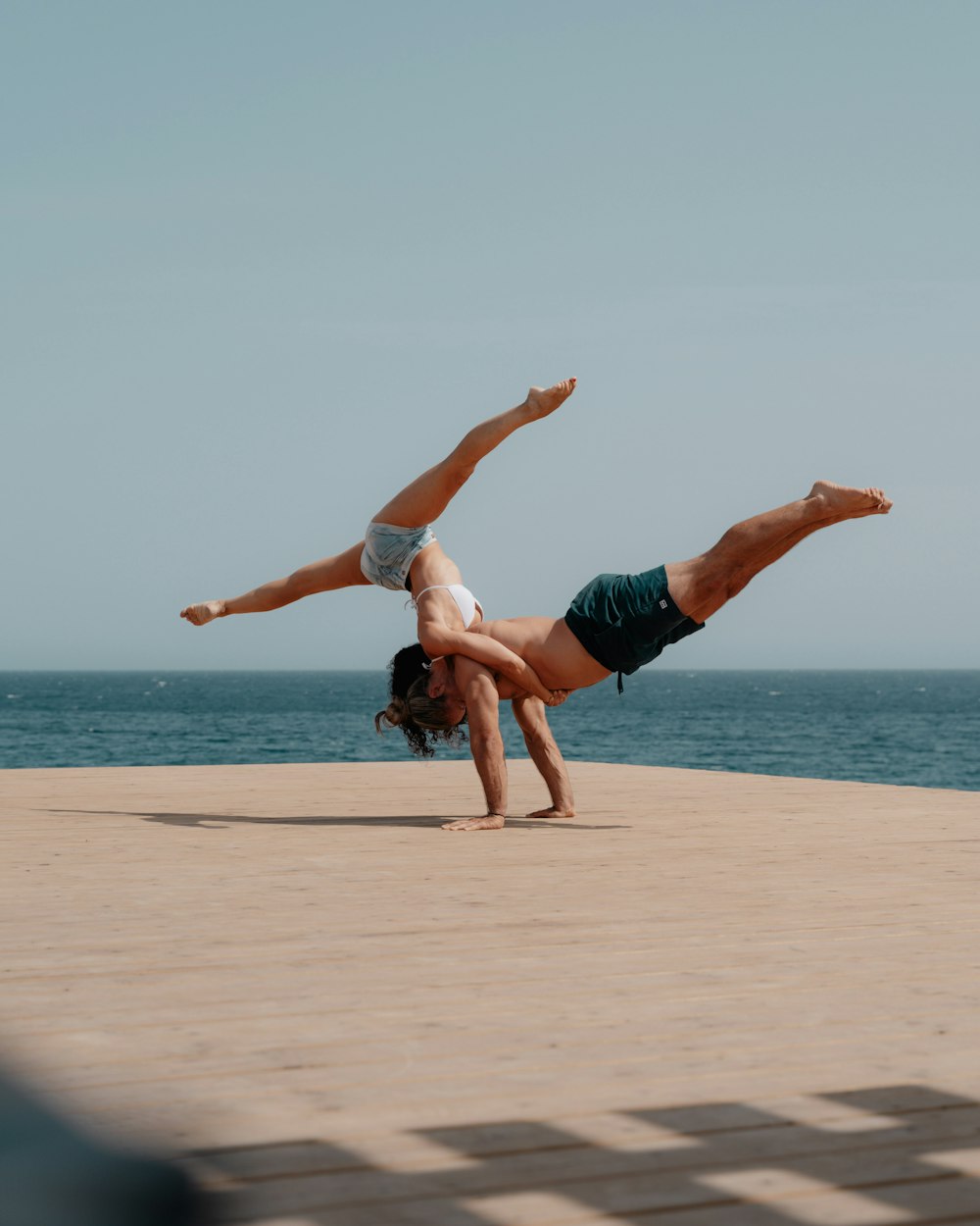 homem em shorts vermelhos pulando na praia durante o dia