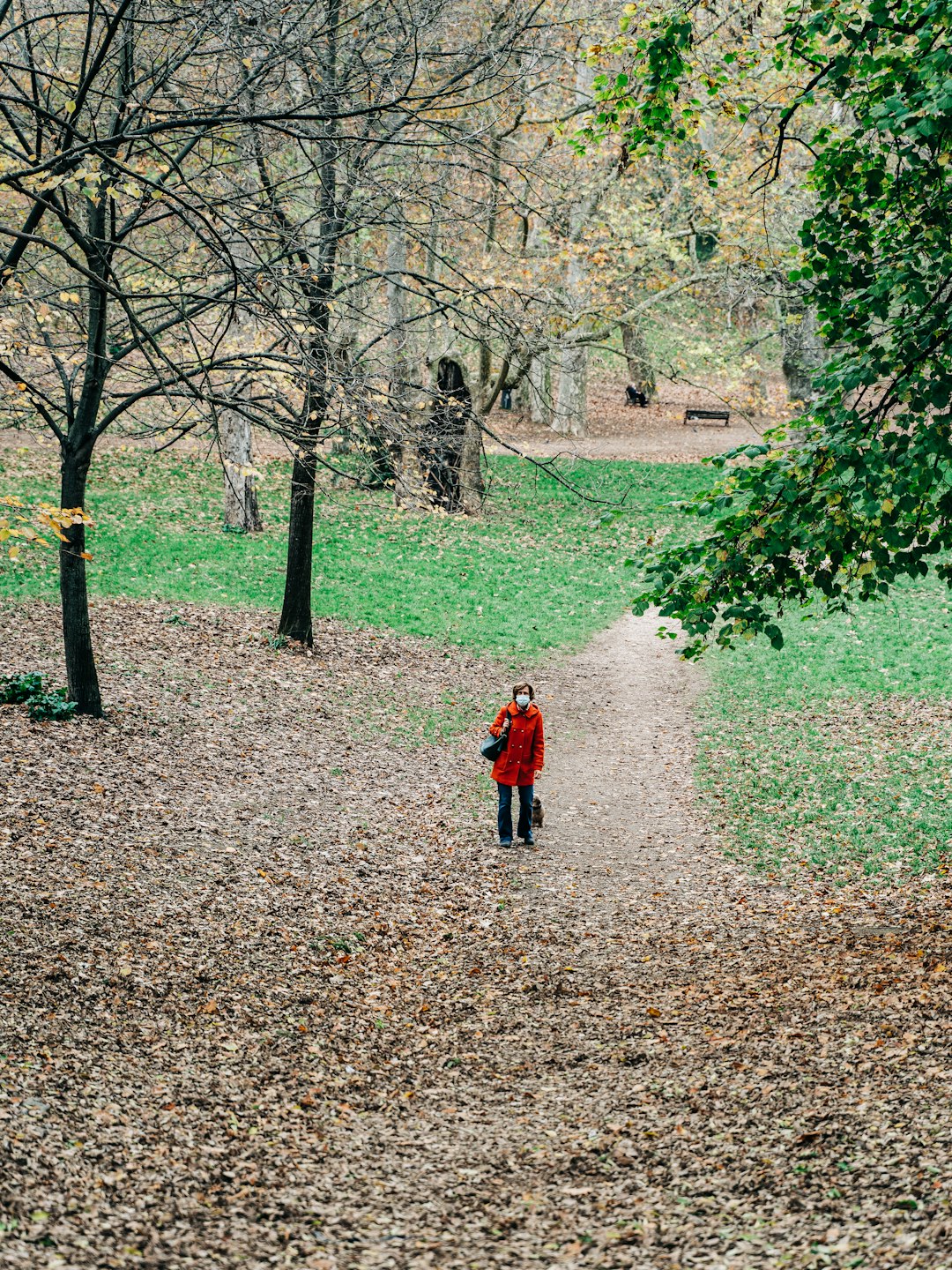 person in red jacket walking on brown dirt road