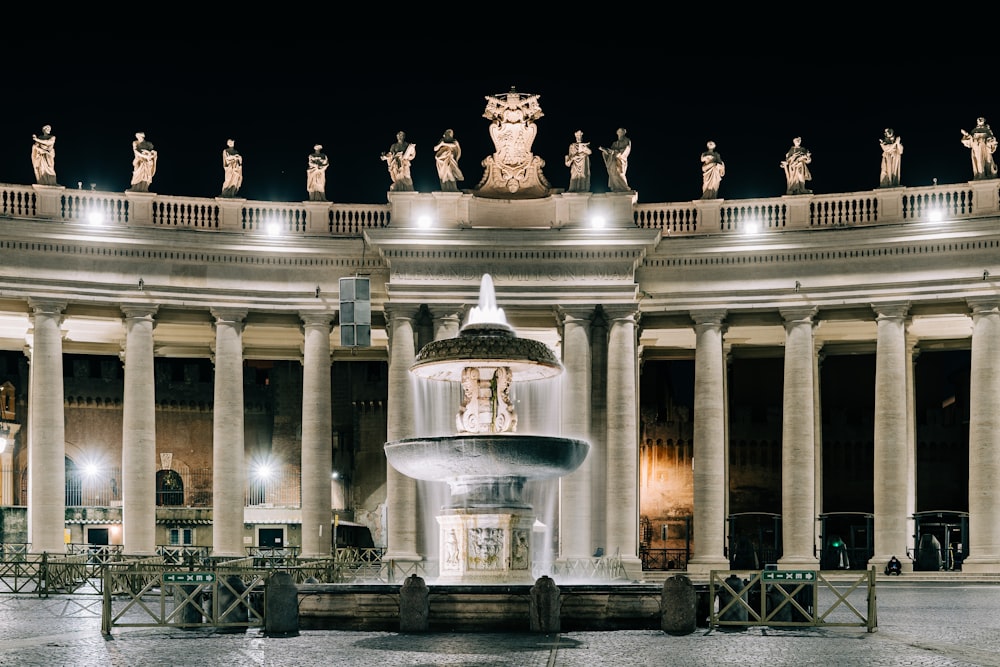 water fountain in front of building during night time