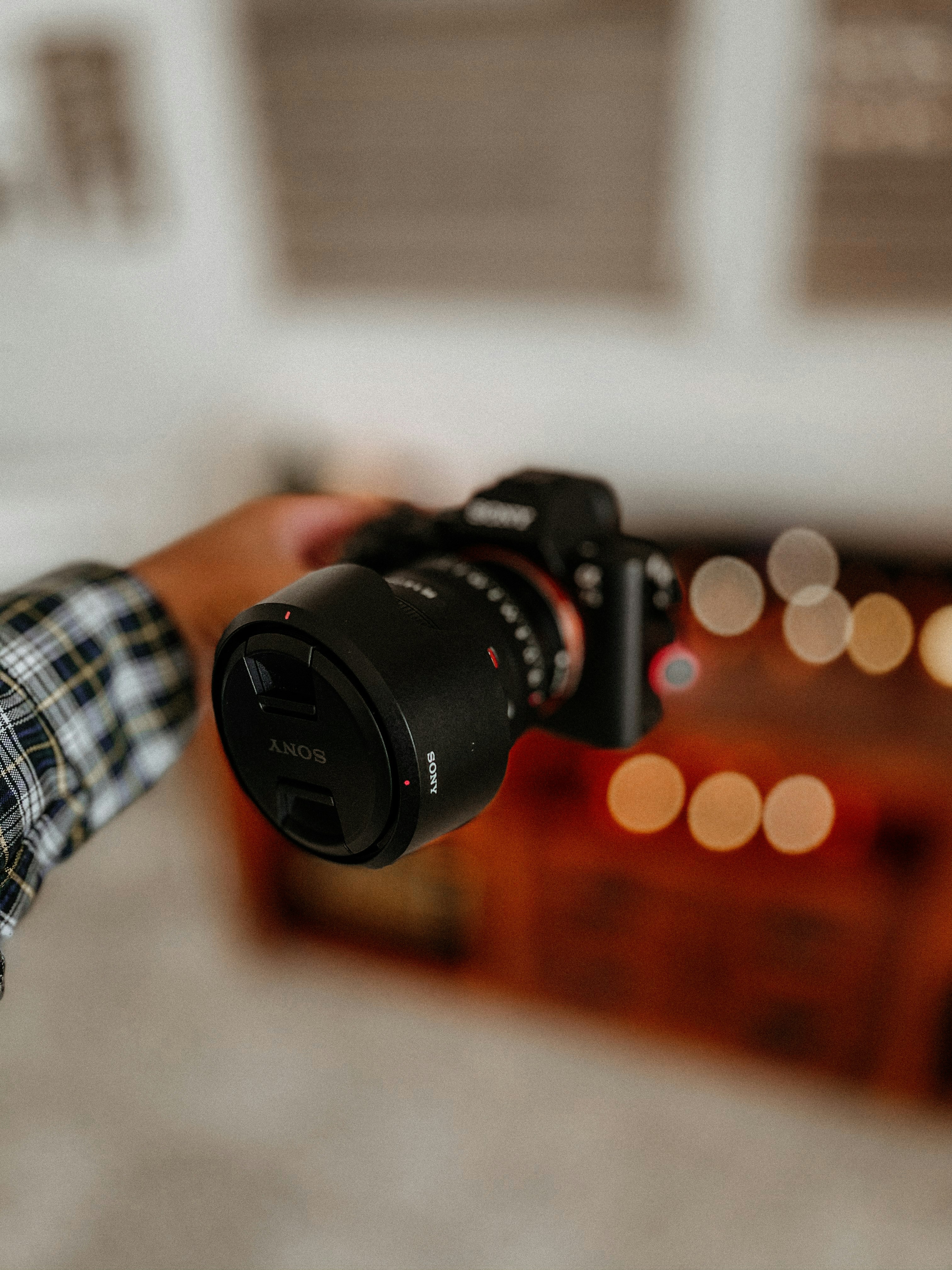 person holding black canon dslr camera lens