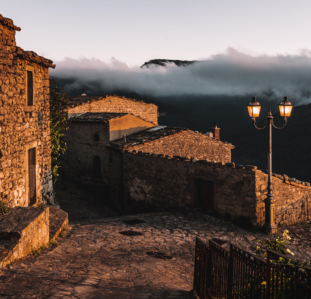 brown brick building near mountain under white clouds during daytime