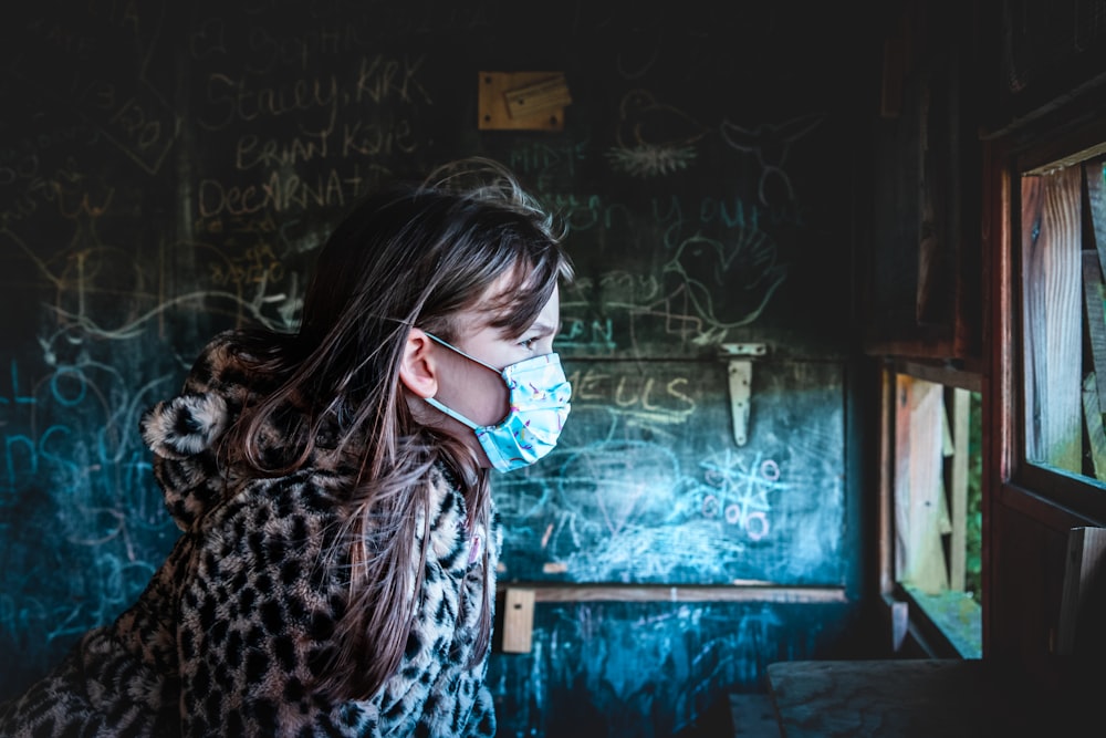 woman in black and white leopard print coat wearing blue goggles