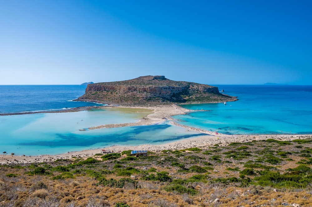 green and brown island on blue sea under blue sky during daytime