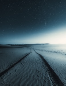 snow covered field under blue sky during night time