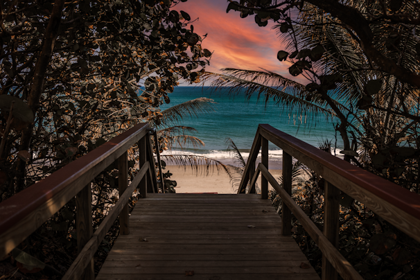 A peaceful pathway leading from the bungalow down to the sandy beach at dawn.