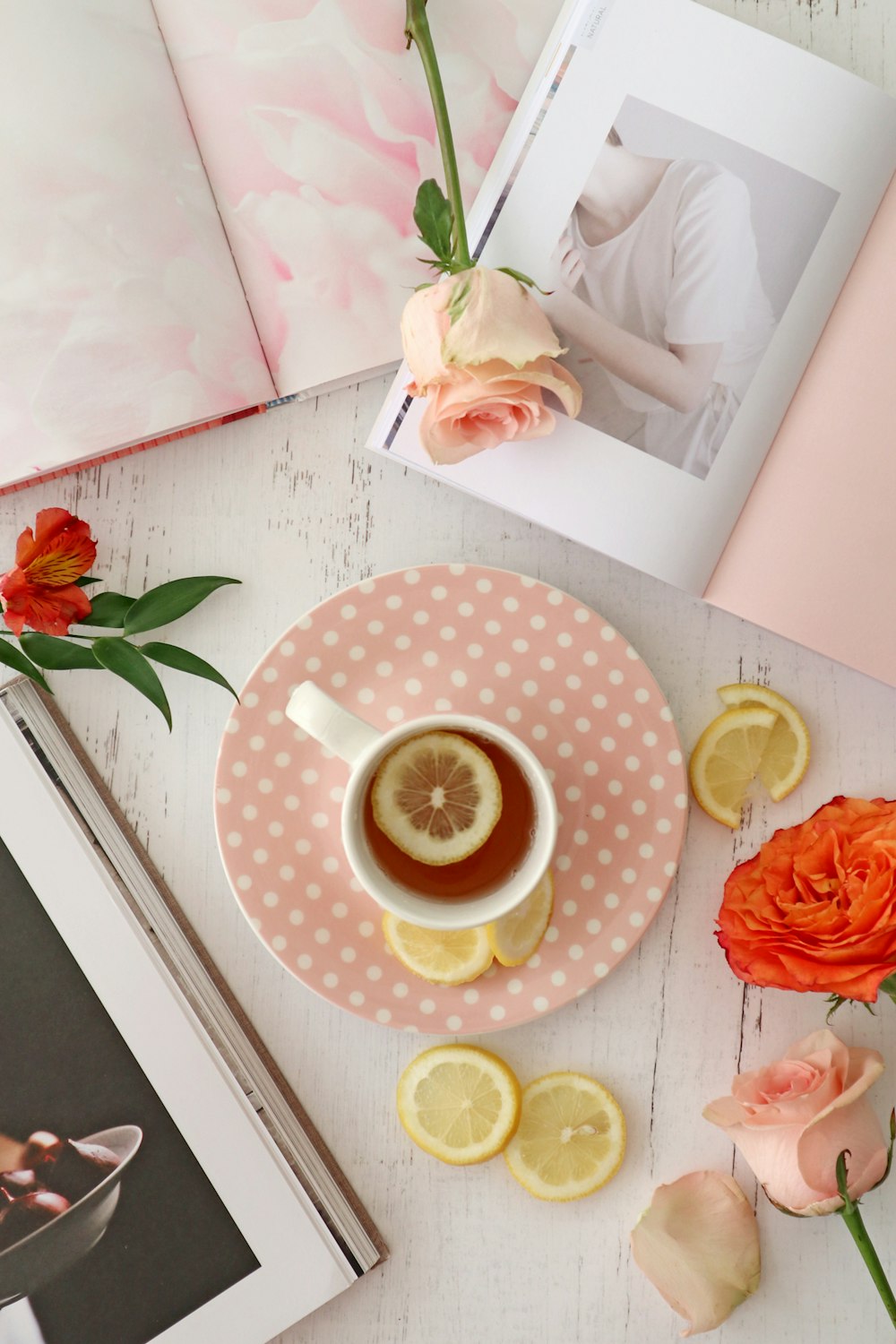 pink rose beside yellow and white polka dot ceramic cup with saucer
