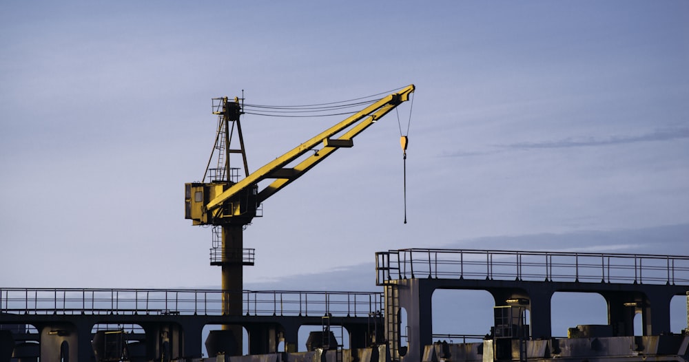 yellow crane near body of water during daytime